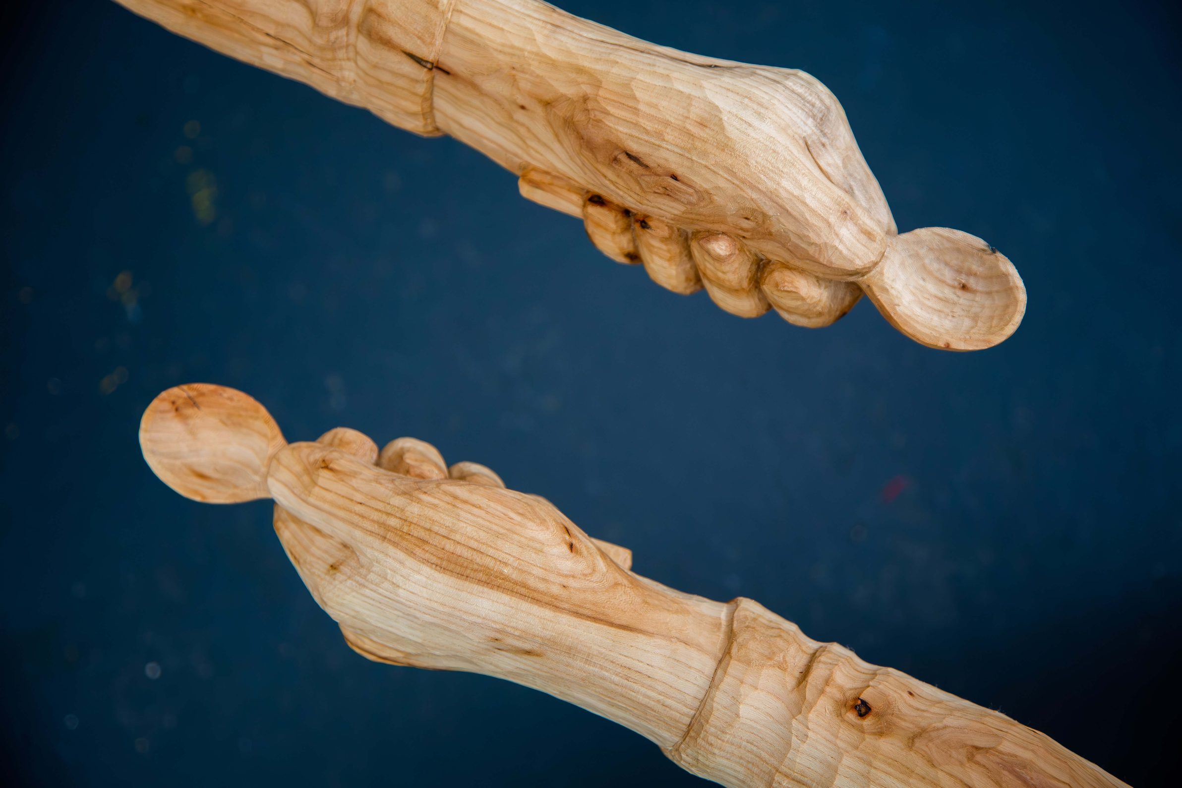 Two wooden hands with spoons